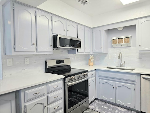 kitchen featuring tasteful backsplash, appliances with stainless steel finishes, and sink