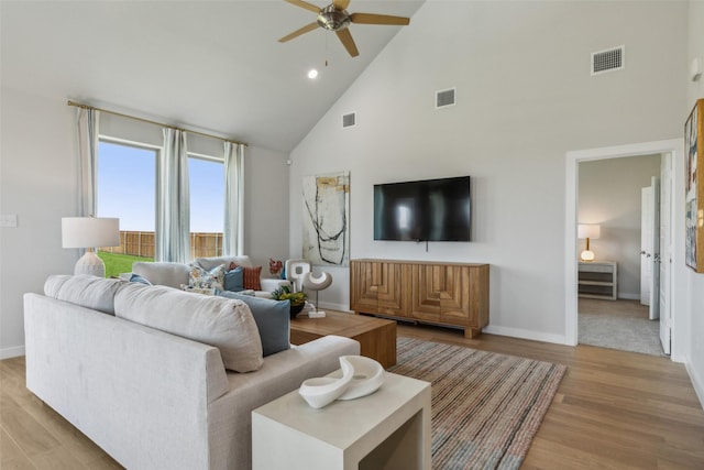 living room with ceiling fan, high vaulted ceiling, and light wood-type flooring
