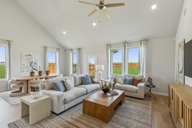 living room featuring ceiling fan, plenty of natural light, high vaulted ceiling, and light hardwood / wood-style floors