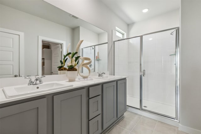bathroom featuring walk in shower, vanity, and tile patterned flooring