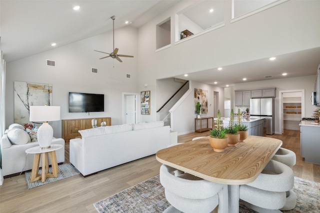 dining space with lofted ceiling, sink, light hardwood / wood-style flooring, and ceiling fan