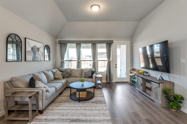 living room with hardwood / wood-style flooring, vaulted ceiling, and plenty of natural light