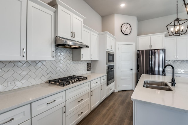 kitchen featuring sink, white cabinetry, dark hardwood / wood-style floors, pendant lighting, and stainless steel appliances