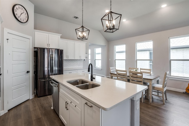 kitchen featuring sink, fridge, white cabinets, a center island with sink, and decorative light fixtures