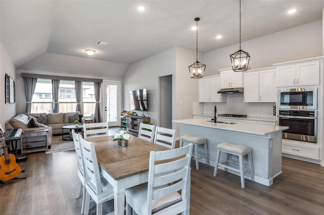 dining space with vaulted ceiling, sink, and dark hardwood / wood-style flooring