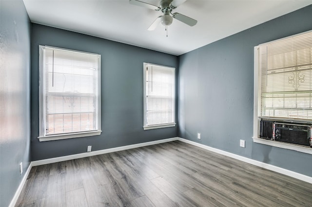 spare room with cooling unit, hardwood / wood-style flooring, a wealth of natural light, and ceiling fan