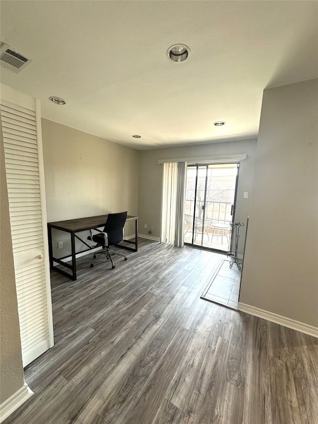 unfurnished office featuring baseboards, visible vents, and dark wood-style flooring