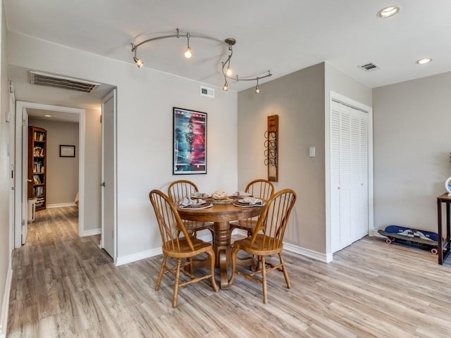 dining room with baseboards, visible vents, and light wood-style floors