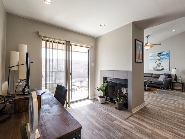 office area with recessed lighting, a fireplace, baseboards, and wood finished floors