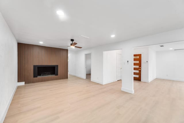 unfurnished living room with ceiling fan and light hardwood / wood-style flooring