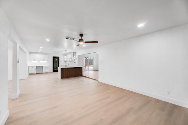 unfurnished living room with ceiling fan and light hardwood / wood-style floors