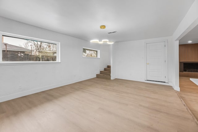 unfurnished room featuring an inviting chandelier and light hardwood / wood-style floors