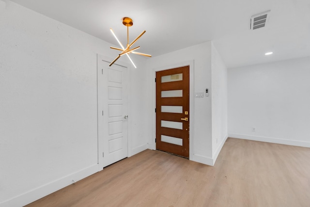 entryway with a chandelier and light hardwood / wood-style floors