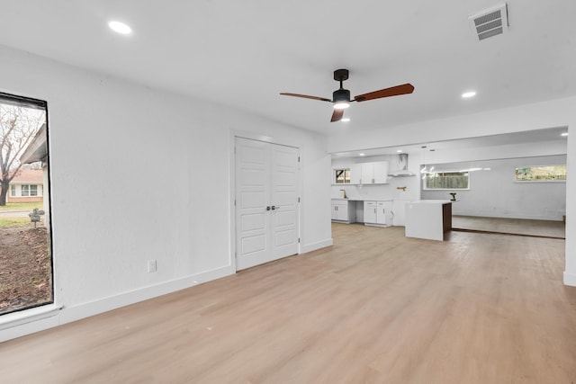 unfurnished living room with ceiling fan and light hardwood / wood-style flooring