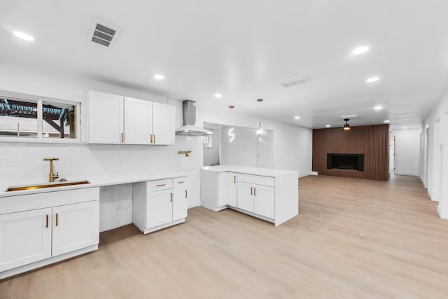 kitchen featuring white cabinetry, extractor fan, a fireplace, and decorative light fixtures