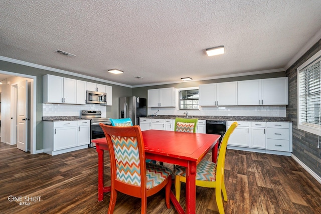 dining space featuring crown molding, a healthy amount of sunlight, and dark wood-type flooring