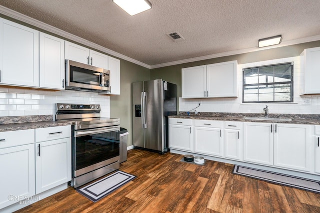 kitchen featuring white cabinetry, appliances with stainless steel finishes, dark hardwood / wood-style floors, and crown molding