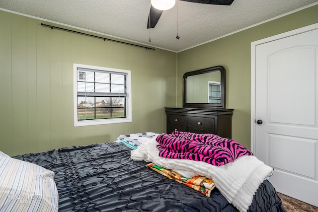 bedroom with ornamental molding, ceiling fan, and a textured ceiling