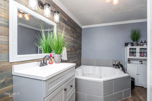 bathroom with crown molding, a textured ceiling, vanity, tiled bath, and hardwood / wood-style floors