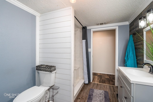 bathroom with curtained shower, hardwood / wood-style flooring, vanity, toilet, and a textured ceiling
