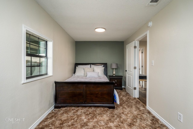 bedroom with dark carpet and a textured ceiling