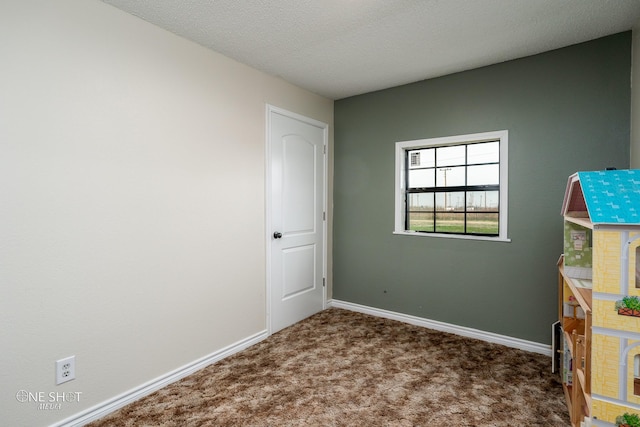 unfurnished room featuring carpet flooring and a textured ceiling