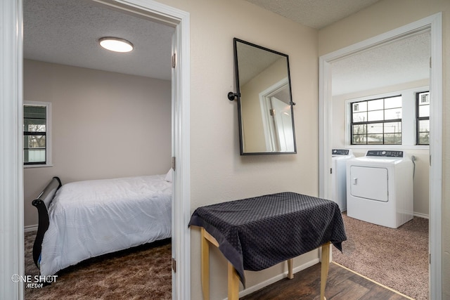 carpeted bedroom with a textured ceiling and independent washer and dryer