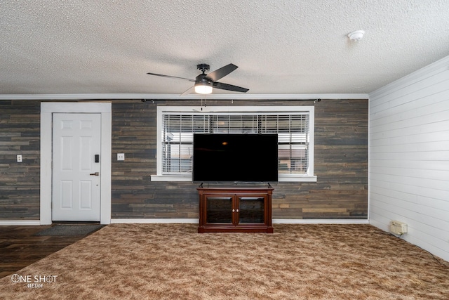 unfurnished living room featuring ornamental molding, dark carpet, and a textured ceiling