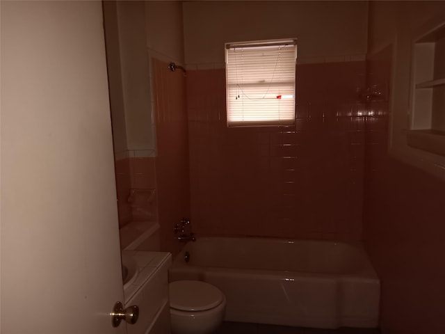 full bathroom featuring vanity, tiled shower / bath, and toilet