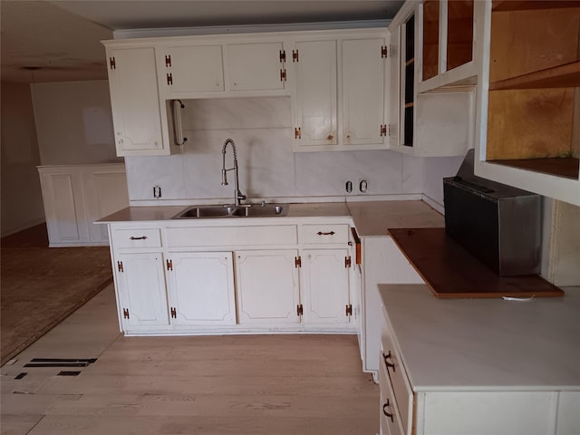 kitchen featuring sink, white cabinets, and light hardwood / wood-style flooring