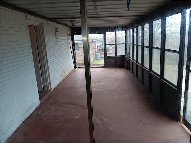 unfurnished sunroom with ceiling fan