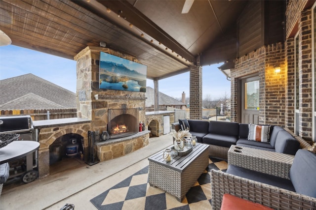 view of patio / terrace featuring an outdoor living space with a fireplace and fence