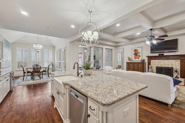 kitchen featuring pendant lighting, sink, dishwasher, dark hardwood / wood-style floors, and a center island with sink