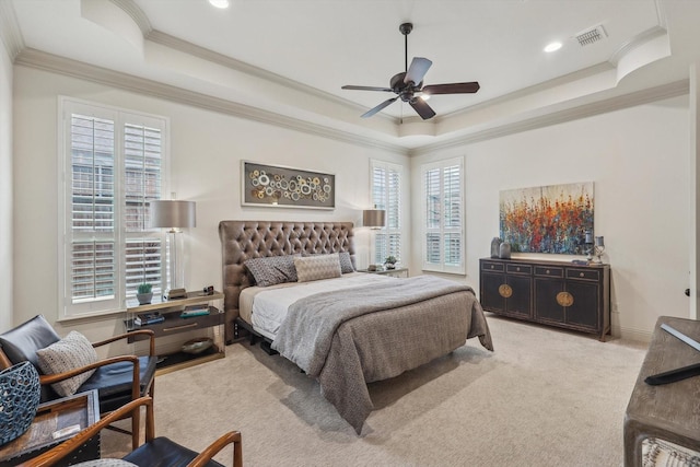 carpeted bedroom with ceiling fan, ornamental molding, and a tray ceiling