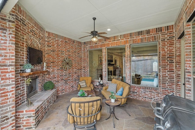 view of patio / terrace featuring an outdoor brick fireplace, grilling area, and ceiling fan