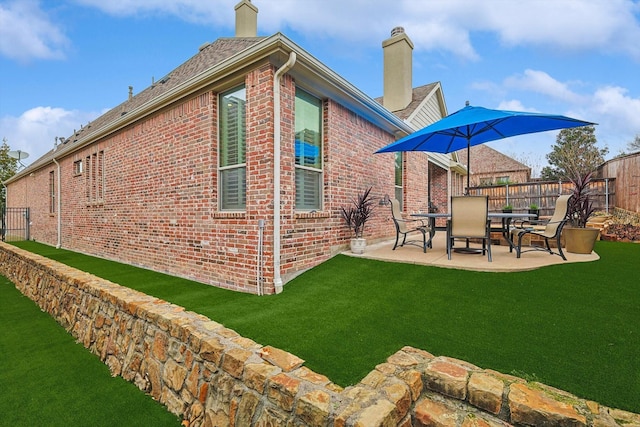 view of side of property with a yard and a patio area