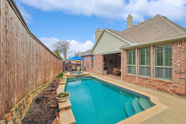 view of swimming pool featuring an in ground hot tub and a patio