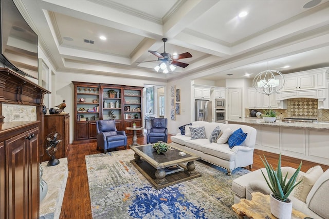 living room with beam ceiling, coffered ceiling, ornamental molding, dark hardwood / wood-style flooring, and ceiling fan with notable chandelier