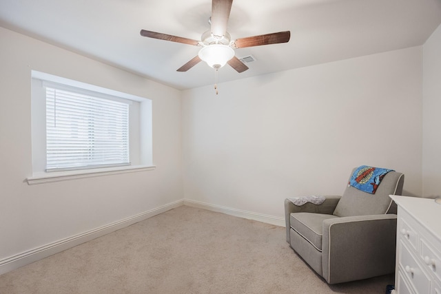 living area featuring light carpet, baseboards, visible vents, and a ceiling fan