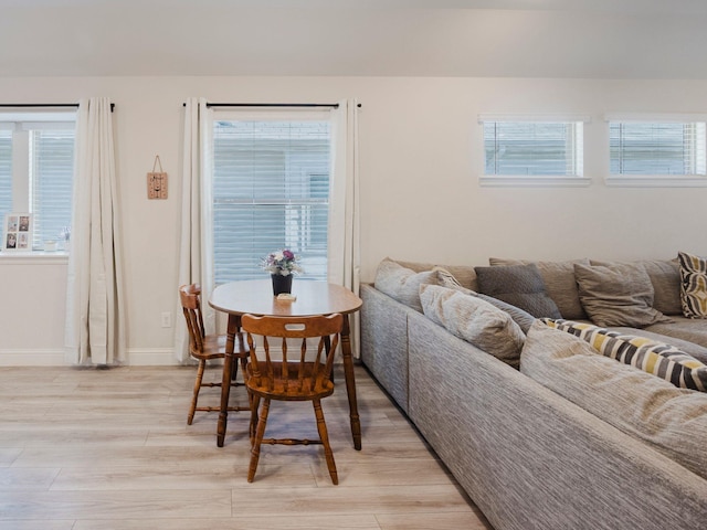 dining area with light wood-style flooring and baseboards