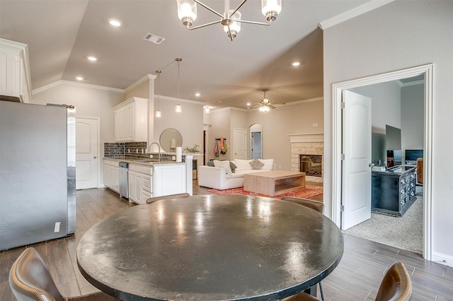 dining space with a barn door, sink, dark hardwood / wood-style flooring, and ceiling fan with notable chandelier