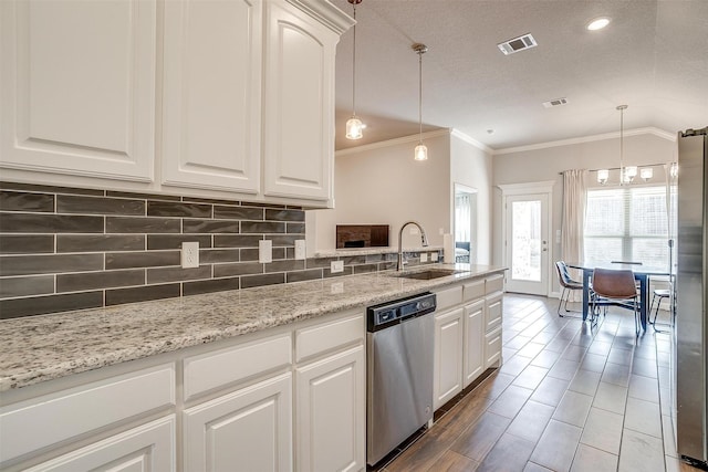 kitchen with pendant lighting, appliances with stainless steel finishes, sink, and white cabinets