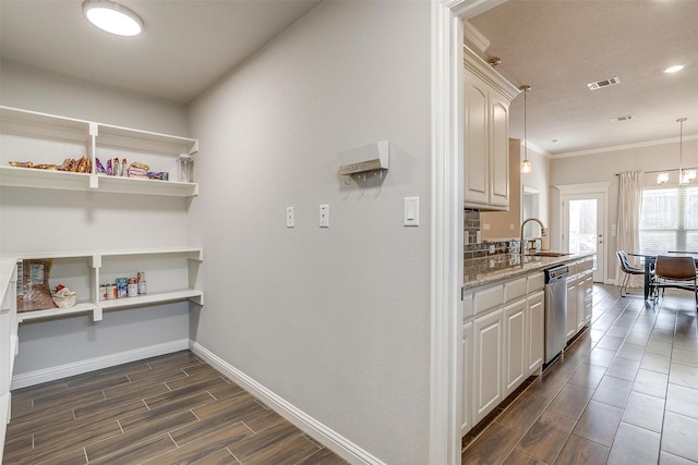 kitchen featuring sink, white cabinetry, crown molding, dishwasher, and pendant lighting