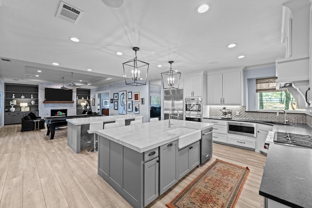 4800 Lusk Ln, Flower Mound, TX 75028 - kitchen with gray cabinetry, stainless steel appliances, a sink, an island with sink, and open floor plan