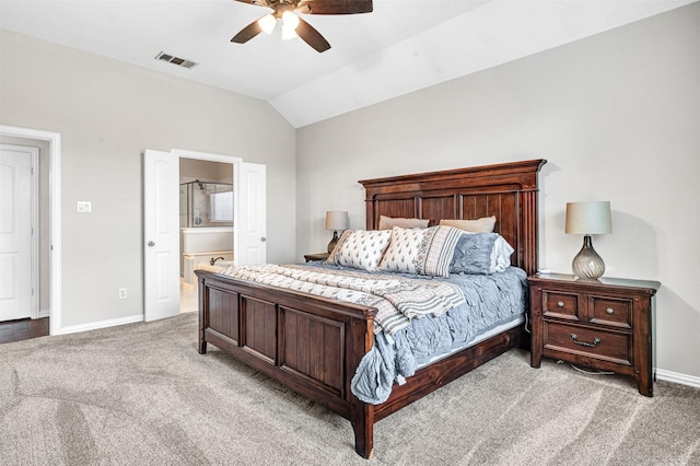 bedroom with ceiling fan, lofted ceiling, connected bathroom, and light carpet