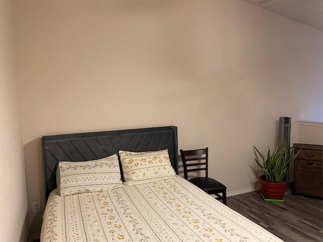 bedroom with dark hardwood / wood-style flooring