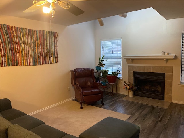 living room featuring ceiling fan, dark hardwood / wood-style floors, and a fireplace