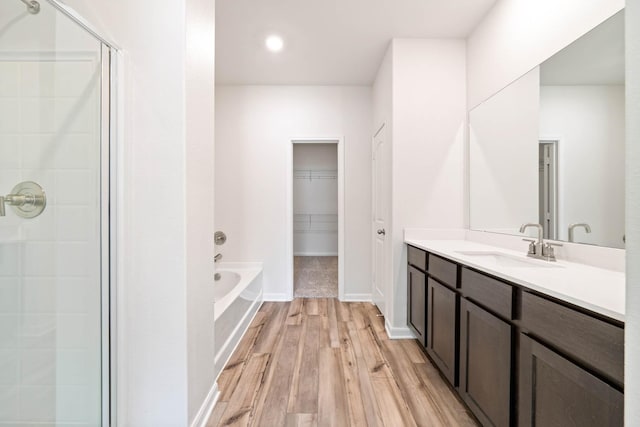 bathroom with shower with separate bathtub, hardwood / wood-style floors, and vanity