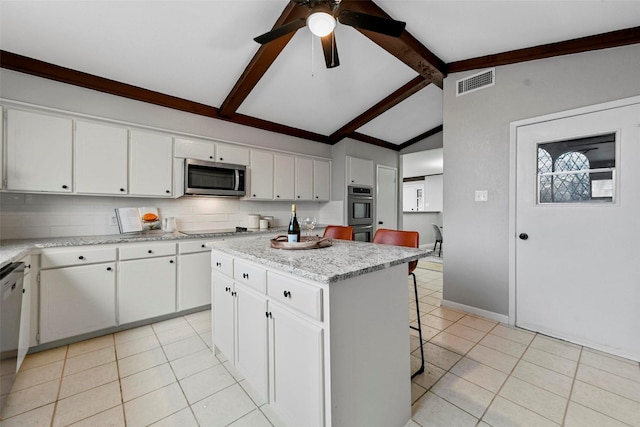 kitchen featuring lofted ceiling with beams, light tile patterned floors, visible vents, and stainless steel appliances