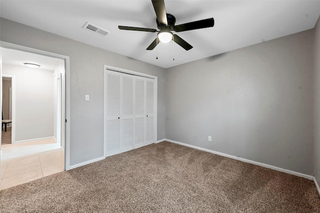 unfurnished bedroom featuring baseboards, visible vents, a closet, and light colored carpet